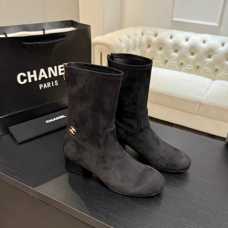 Chanel black suede mid-calf boots with gold CC logo hardware, shown with Chanel shopping bag